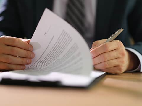 A man and woman shaking hands across a table